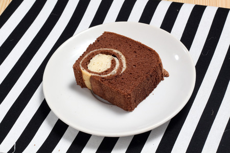 slice belgium chocolate cake on plate and black and white strips clothの写真素材