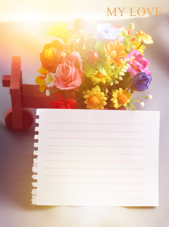 close up decorative rose and notepad paper space for textの写真素材