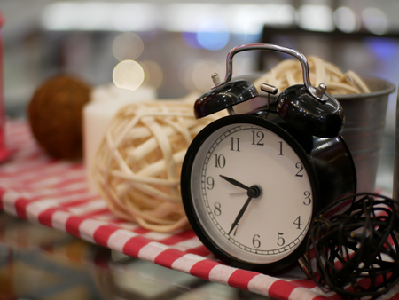 lantern candle and alarm clock with red and white fabric artificial flowers bouquet home decoration concept on bokeh backgroundの写真素材
