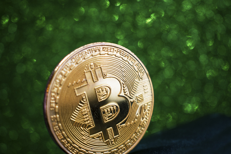 golden bitcoin coin with sparkle glitter green background, crypto currency concept.の写真素材