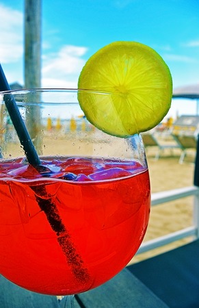 Colorful cocktail drink on wood table in beach bar, soft focus