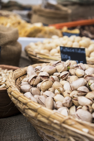 Background of basket of pistachios with shells, captured on street market, selective focusの写真素材