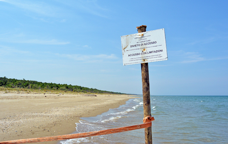Warning Sign on the beach of the nature reserve at the mouth of the river Bevano, with the inscription: State Forestry Corps. Nature reserve. from 1 April to 15 June: access fee with limitationsの写真素材