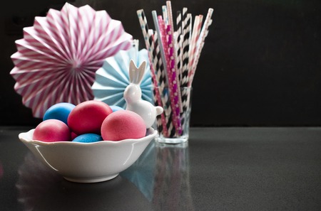 Easter holiday creative  with eggs, porcelain bunny and paper decoration. White, pink, blue color on...