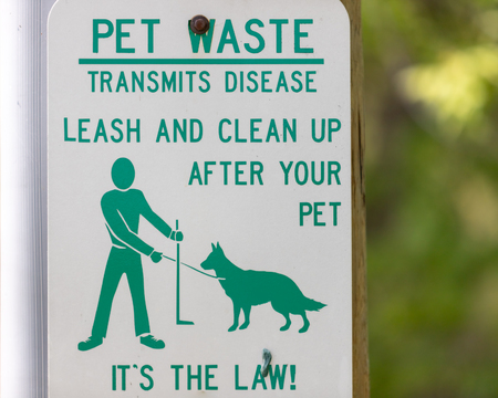 Park sign asking you to pick up your pets waste.の写真素材