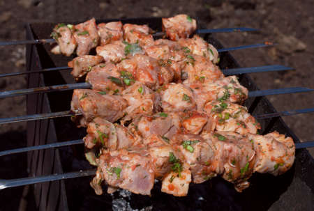 raw shish kebab on skewers is cooking の写真素材