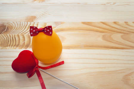 egg decorated with bow and velvet heart on wooden backgroundの写真素材