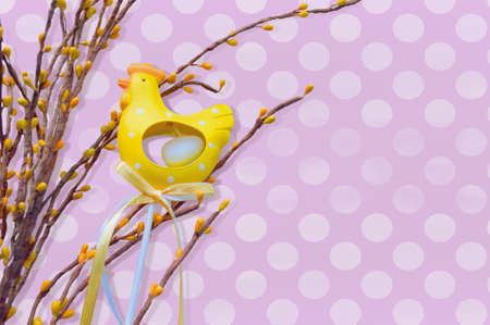 yellow hen with spring branches on violet spotted backgroundの写真素材