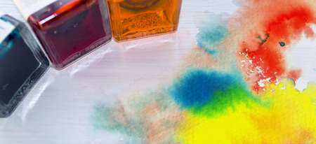 close up view of 3 watercolor paint bottles; blue, red and yellow
