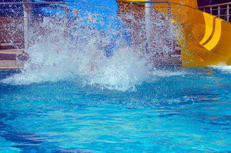landing in swimming pool slitheringin water slide with a lot of  splashes