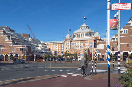 Hague, The Netherlands, October 05, 2018: Woman on the bicycle waiting for green traffic light in front of Grand hotel Amrath Kurhausのeditorial素材