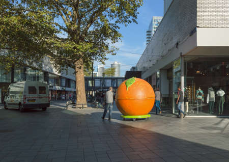 Rotterdam, The Netherlands, October 6, 2018: Man is trundling his small business store made as an orange on the street of Rotterdam in the morningのeditorial素材