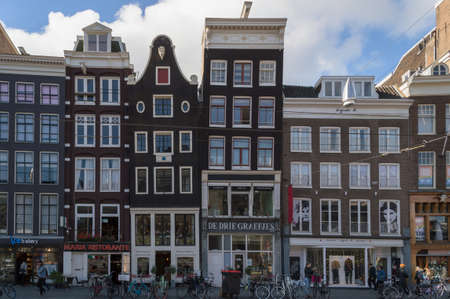 Amsterdam, The Netherlands, October 07, 2018: Facades of historic houses with first floor shops and parked bicyclesのeditorial素材