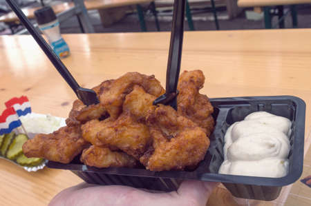 close up of traditional and famous in Netherlands fryed fish - kibbeling  served with sauce mayonnaiseの写真素材
