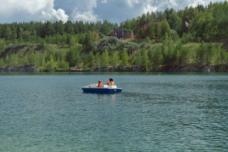 catamaran activity by unidentified people at beautiful lake surrounded by forestの写真素材