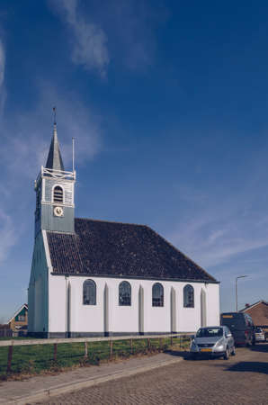 Oudeschild,Texel, The Netherlands, October 13, 2018: Zeemanskerk Oudeschild protestant church with parked cars on sunny autumn dayのeditorial素材