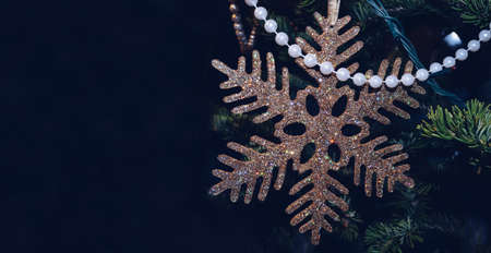 sparkling golden snowflake with dark background and space for text
