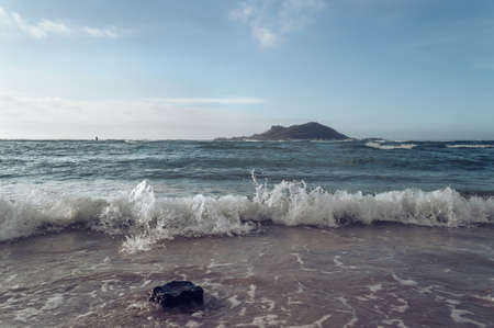low angle view on sea waves and small island from Geumneung  beachの写真素材