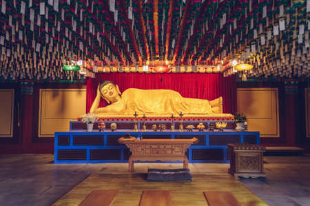 Busan, South Korea, September 12, 2019: Lying golden buddha inside Haedong Yonggung Temple with...