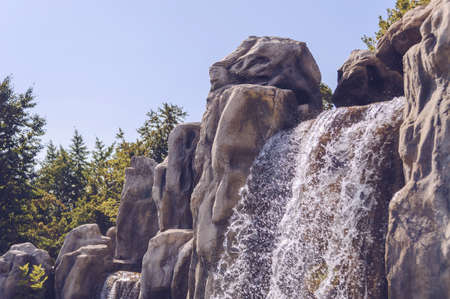 sparkling in sunlight waterfall with blue skies on background and treesの写真素材
