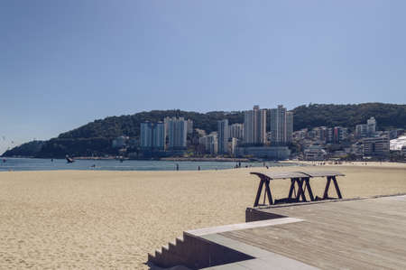 part of wooden platform and swings in front of Songdo beach in Busan on sunny dayの写真素材