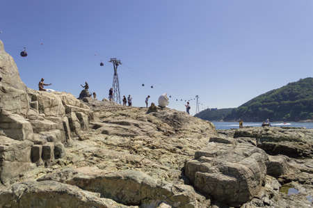 Busan, South Korea, September 14, 2019: people walking on  rocky place with sculptures and cable cars on backgroundのeditorial素材