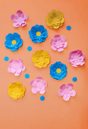 cute handmade paper flowers on orange background with space for text