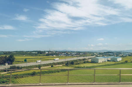 view from above on road through small south korean village surrounded by growing cropsの写真素材
