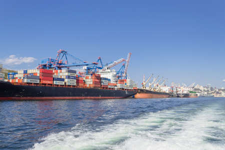 Vladivostok, Russia - October 07, 2020: Large industrial ships with cargo cranes and goods