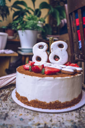 side view of homemade birthday cake with 88 edible numbers on it and years written in russianの写真素材