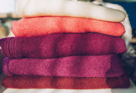 stack of warm cashmere sweaters in color variety as spring cleaning or winter preparation conceptの写真素材