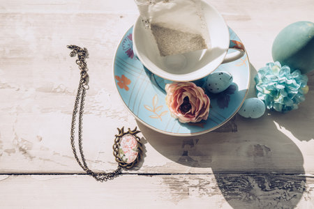 love and memories concept with blue porcelain tea set and vintage bronze pendantの写真素材