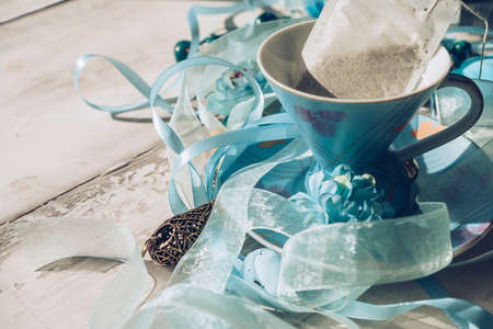 close up view of blue chinese porcelain tea set with tea bag inside and decorative ribbons aroundの写真素材