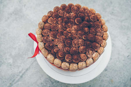 close up view view from above on homemade organic tiramisu cake decorated with red ribbonの写真素材