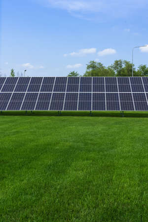 close up view of solar panel with green grass lawn and blue sky