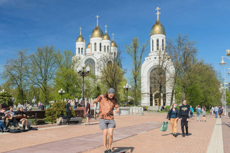 Kaliningrad, Russia - may 10, 2021: young people relaxing and having fun at the square of victory with orthodox chapel and cathedral on backgroundのeditorial素材
