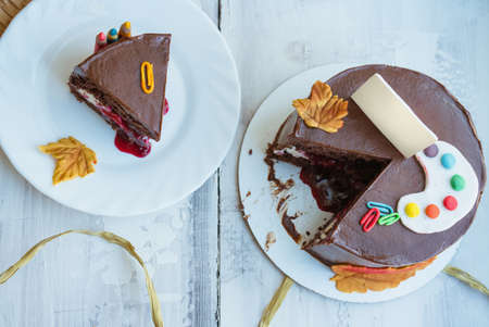top view of chocolate cake decorated in back to school theme with sugar palette clips fall leaves...