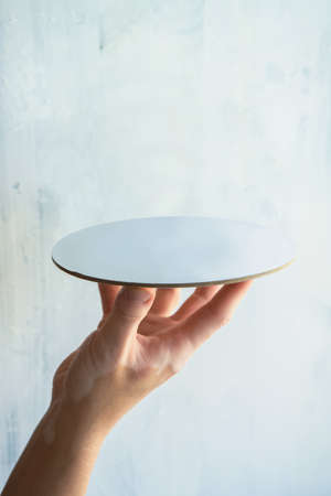 woman's hand holding empty plate with white background product template with space for text and item