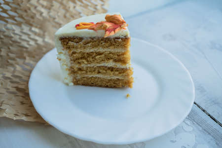 close up view of piece of cake decorated with autumn leaves