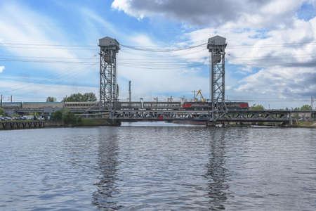 Kaliningrad, Russia - may 14, 2021: closed vertical lift bridge with moving train and pregolya river...