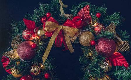 decorated with red and golden decor christmas wreath with illumination and festive vow tiedの写真素材