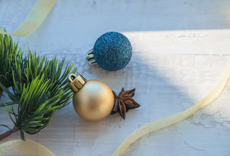 winter holidays decor background with golden ribbon christmas balls and star anise on white wooden backgroundの写真素材