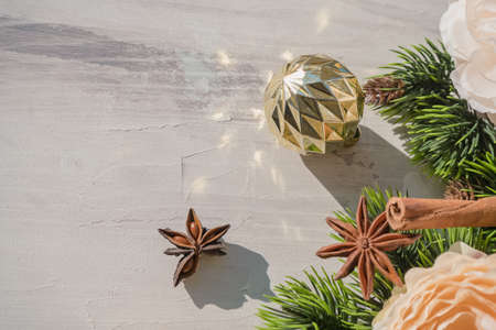 winter holidays background with sparkling golden christmas ball fir tree branch and spicesの写真素材