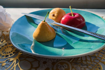 cut fruits apple and pear on the plate concept of beautiful 'made' food that cant be eaten (beauty outside- ugly inside)の写真素材
