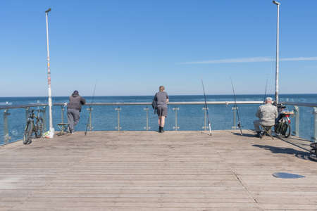 Zelenogradsk, Russia - may 11, 2021: fishermen backs with baltic sea view on the sunny spring dayのeditorial素材