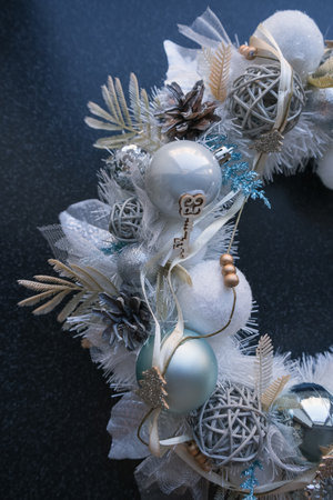 top vertical view of white christmas wreath with shiny decor on dark backgroundの写真素材
