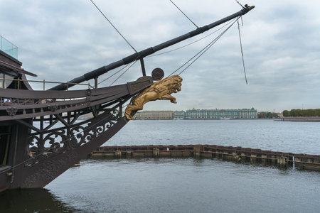 Saint Petersburg, Russia - September 29, 2021: galleon figure of golden lion at Sailboat Flying Dutchman and cityscape on backgroundのeditorial素材