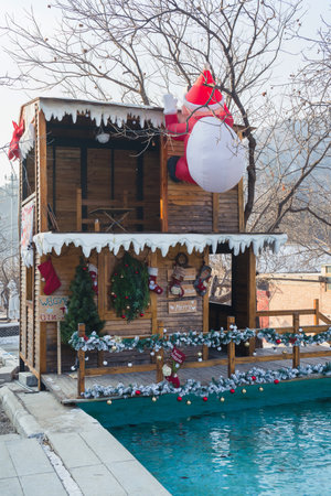 Big santa claus climbing at the house Christmas decoration at winter time in suburbanの写真素材