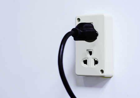 Electrical outlet with black power cord. Home interior electrical outlet with black power cord and plug againstの写真素材