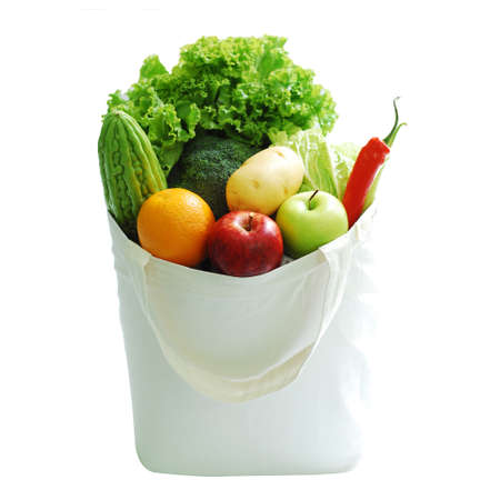 Organic vegetables in a white cloth bag placed on a wooden floor. Healthy food concept, love the world, reduce plastic waste. Clipping path. copy spaceの写真素材